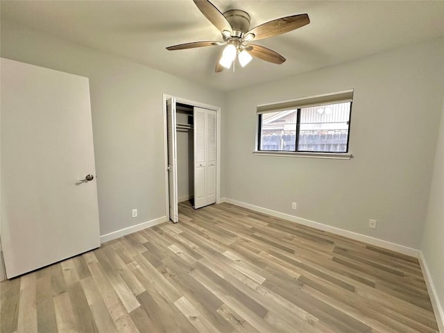 unfurnished bedroom with a closet, a ceiling fan, light wood-type flooring, and baseboards