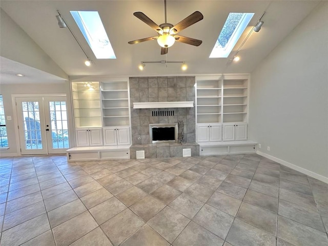 11740 D K Ranch Rd, Austin, TX 78759 - unfurnished living room featuring a skylight, vaulted ceiling, tile patterned floors, rail lighting, and built in shelves
