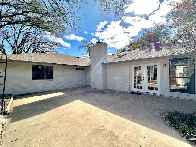 11740 D K Ranch Rd, Austin, TX 78759 - back of property with a chimney, a patio area, brick siding, french doors, and a shingled roof