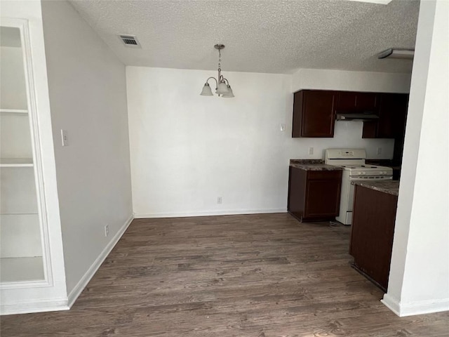 unfurnished dining area featuring baseboards, visible vents, dark wood-type flooring, a textured ceiling, and a notable chandelier