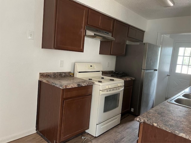 kitchen with electric range, under cabinet range hood, dark countertops, a textured ceiling, and dark wood-style flooring