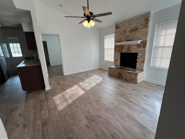 unfurnished living room featuring plenty of natural light, wood finished floors, and a sink