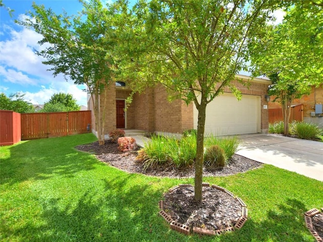 exterior space with brick siding, an attached garage, fence, a yard, and driveway