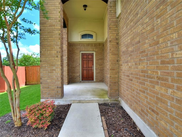 entrance to property with fence and brick siding