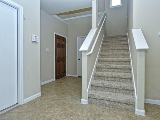 stairway featuring tile patterned flooring and baseboards