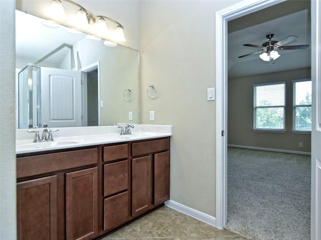 full bath with double vanity, tile patterned flooring, baseboards, and a sink