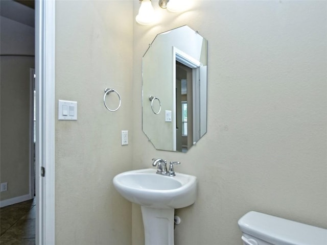 half bathroom with tile patterned floors and toilet