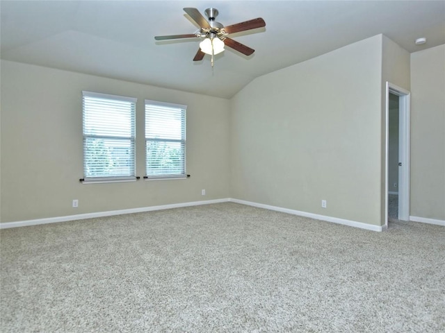 spare room featuring ceiling fan, baseboards, lofted ceiling, and carpet floors