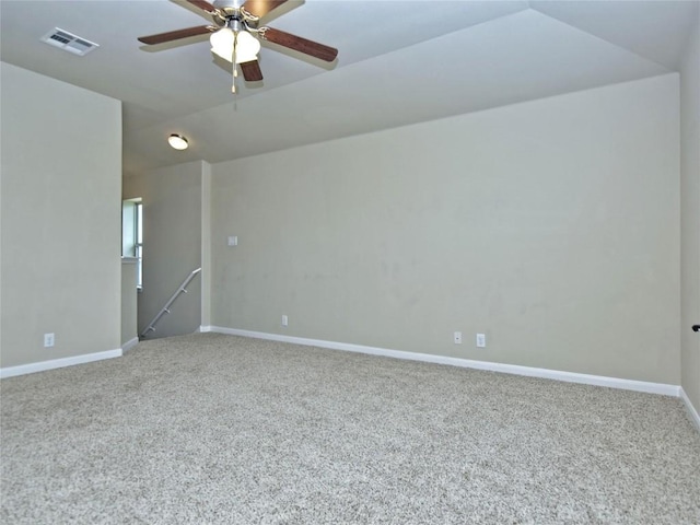 carpeted empty room with visible vents, baseboards, lofted ceiling, and ceiling fan