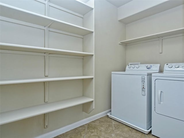 clothes washing area featuring laundry area, independent washer and dryer, and baseboards