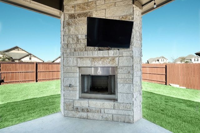 view of patio / terrace with an outdoor stone fireplace and a fenced backyard