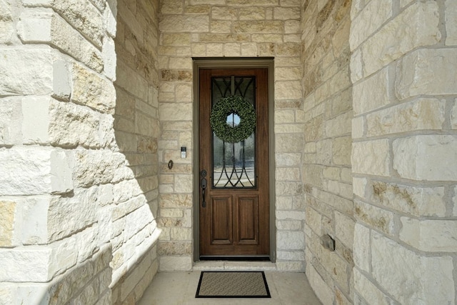 doorway to property with stone siding