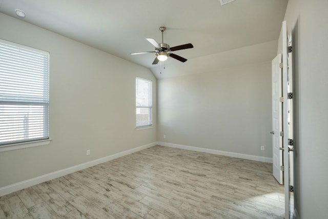 unfurnished room with ceiling fan, baseboards, light wood-style flooring, and vaulted ceiling