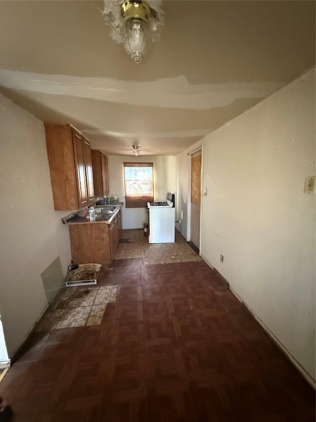 102 Masonic Dr, Elgin, TX 78621 - kitchen with brown cabinetry and white gas stove