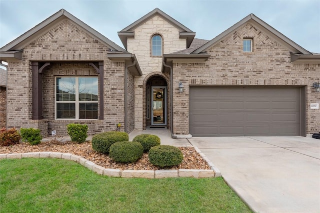 french provincial home with brick siding, driveway, and a garage