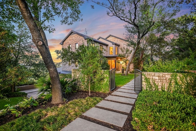 yard at dusk featuring a fenced front yard