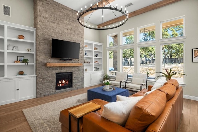 living area with a wealth of natural light, visible vents, a fireplace, and hardwood / wood-style flooring