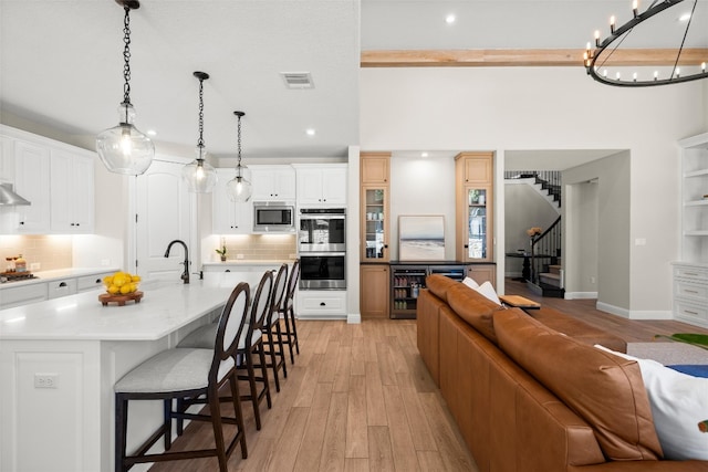 kitchen with a breakfast bar, light wood-style flooring, appliances with stainless steel finishes, and a sink