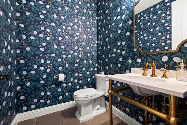 bathroom featuring tile patterned floors, baseboards, toilet, and wallpapered walls