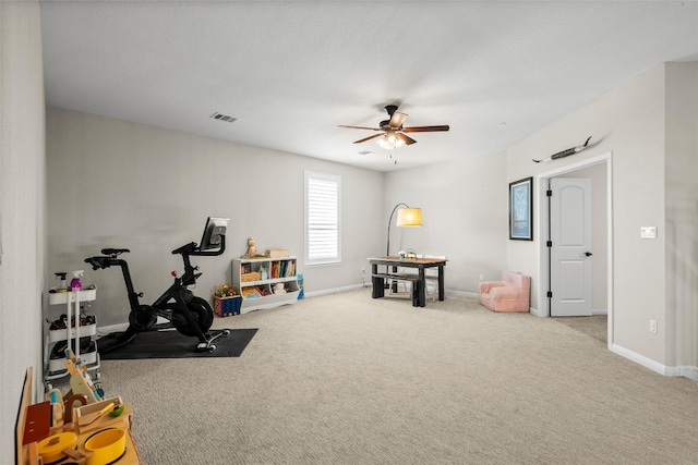 exercise area featuring visible vents, baseboards, ceiling fan, and carpet flooring