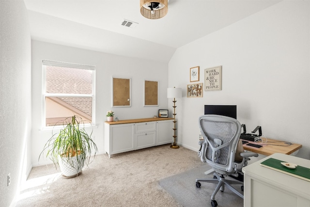 office area with visible vents, baseboards, light colored carpet, and vaulted ceiling