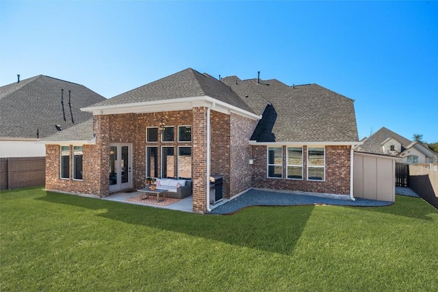 rear view of property featuring a shingled roof, an outdoor living space, a yard, and a patio