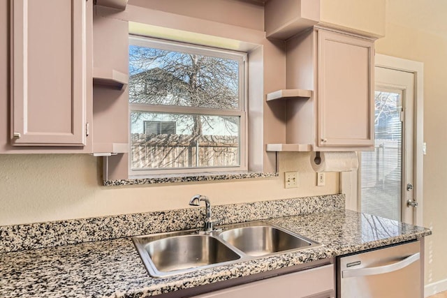 kitchen with a wealth of natural light, open shelves, stainless steel dishwasher, and a sink