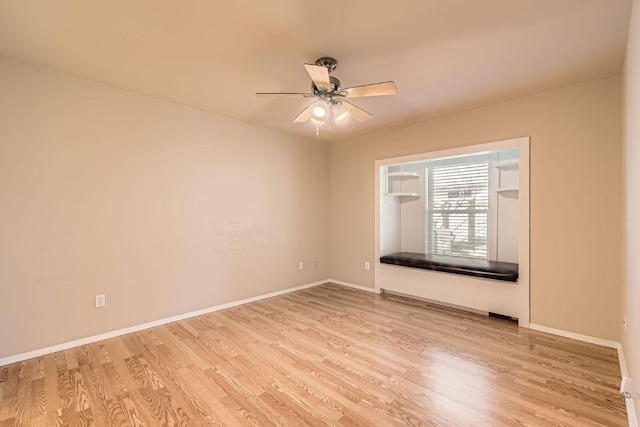 empty room with wood finished floors, baseboards, and ceiling fan