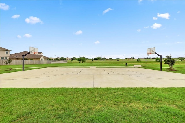 view of basketball court featuring community basketball court, a lawn, and fence