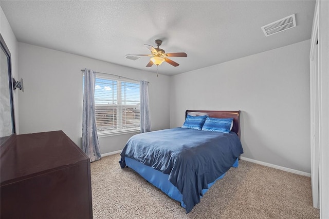 bedroom featuring visible vents, a ceiling fan, a textured ceiling, carpet, and baseboards