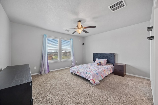 carpeted bedroom with ceiling fan, baseboards, visible vents, and a textured ceiling