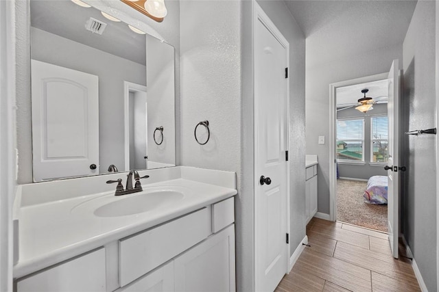 bathroom with visible vents, baseboards, ceiling fan, and vanity