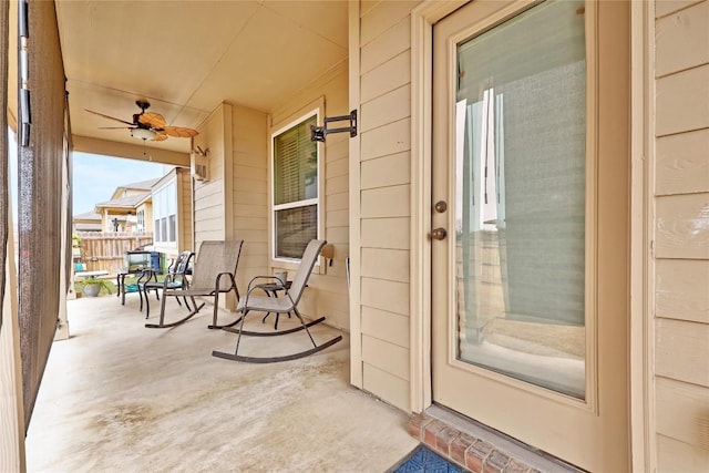 doorway to property with a porch and fence