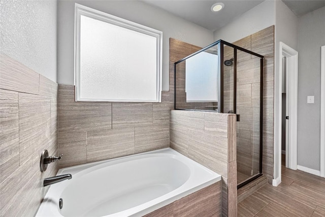 bathroom featuring a garden tub and a stall shower