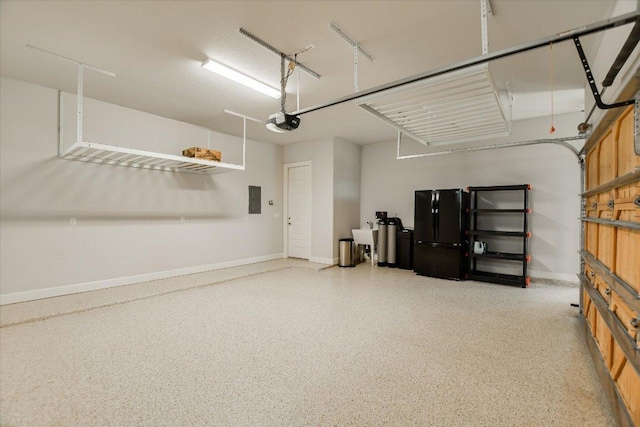 garage featuring electric panel, a garage door opener, and baseboards