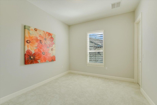 carpeted spare room featuring visible vents and baseboards