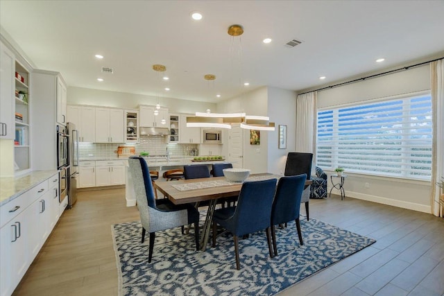 dining room with recessed lighting, visible vents, baseboards, and wood finished floors