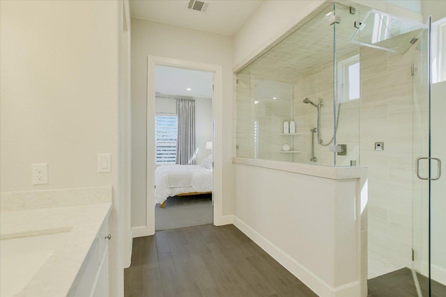 ensuite bathroom featuring visible vents, baseboards, a stall shower, ensuite bathroom, and wood finished floors