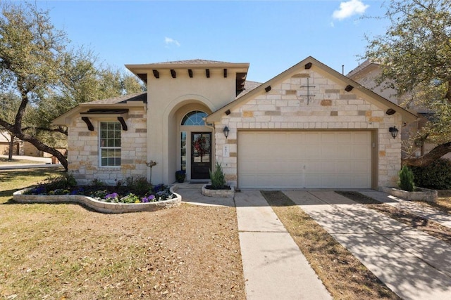 mediterranean / spanish home featuring a garage, stone siding, and driveway