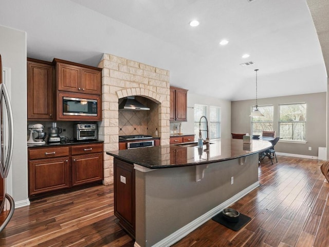 kitchen featuring stainless steel microwave, visible vents, dark wood-style flooring, and a sink