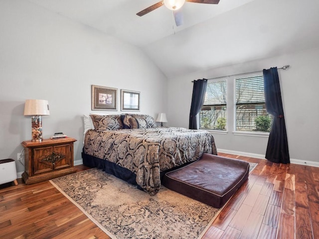 bedroom with a ceiling fan, vaulted ceiling, wood finished floors, and baseboards