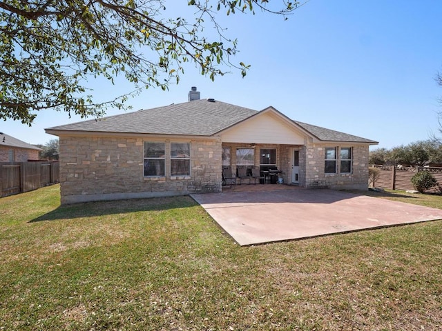 back of property with a patio, a lawn, a fenced backyard, and a chimney