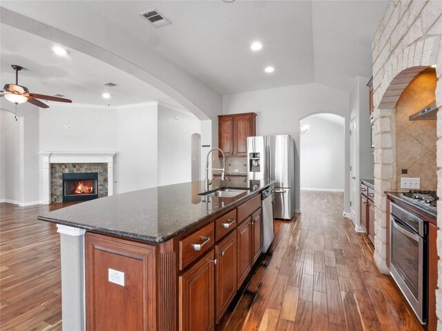 802 Wood Mesa Dr, Round Rock, TX 78665 - kitchen with stainless steel appliances, a fireplace, brown cabinetry, ceiling fan, and recessed lighting