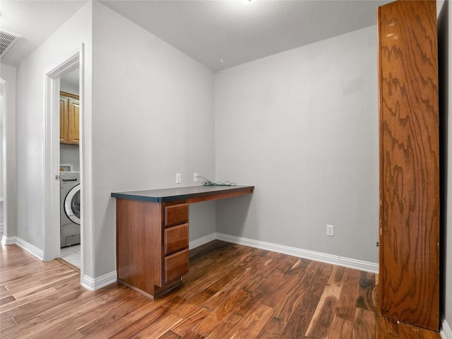 802 Wood Mesa Dr, Round Rock, TX 78665 - unfurnished office featuring washer / clothes dryer, wood finished floors, and built in desk