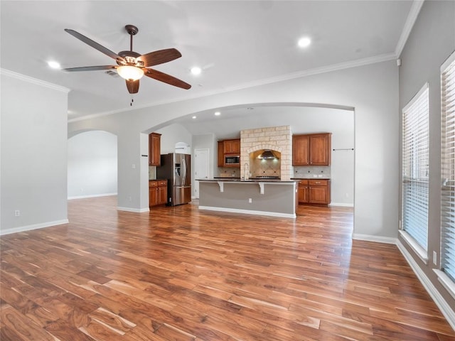802 Wood Mesa Dr, Round Rock, TX 78665 - unfurnished living room with ornamental molding, arched walkways, wood finished floors, ceiling fan, and recessed lighting