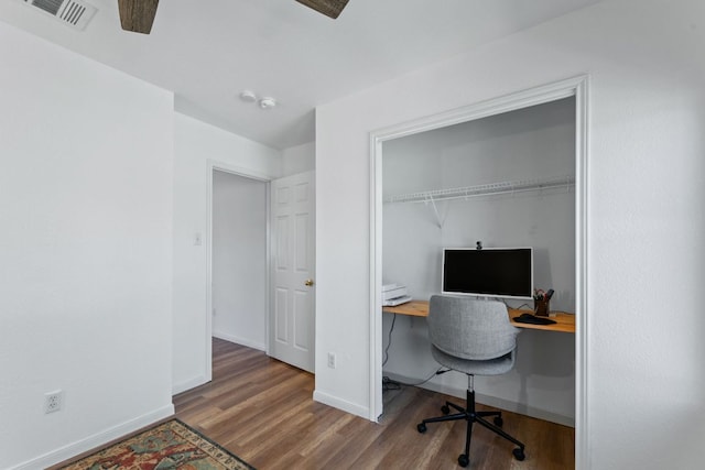 home office featuring ceiling fan, wood finished floors, visible vents, and baseboards