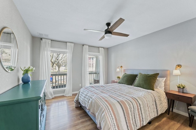 bedroom with visible vents, a ceiling fan, access to outside, wood finished floors, and baseboards