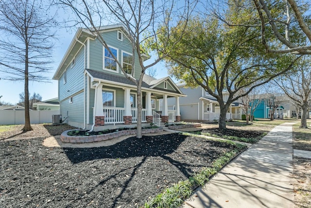 view of front facade with cooling unit, a porch, and fence