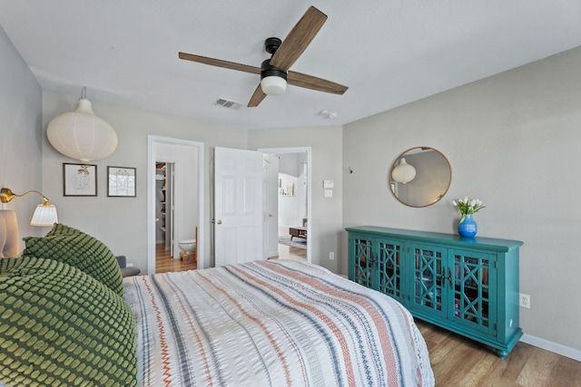 bedroom with visible vents, a ceiling fan, baseboards, and wood finished floors