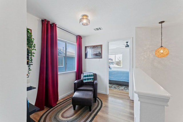 sitting room with visible vents, a healthy amount of sunlight, light wood-type flooring, and baseboards